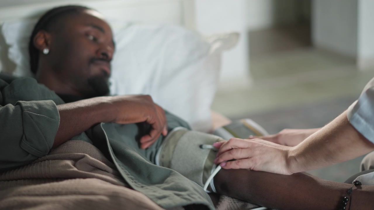 L'assistente misura la pressione sanguigna con calma. Un paramedico compassionevole assiste il paziente con delicatezza. Una visita domiciliare serale da parte di un paramedico premuroso garantisce il comfort del paziente e una valutazione sanitaria precisa