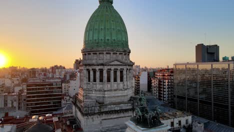 Aerial-orbit-of-Argentine-Congress-Palace-green-bronze-dome-surrounded-by-Buenos-Aires-buildings-at-golden-hour