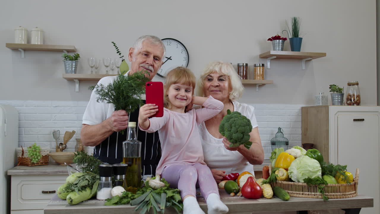 Blogger-Mädchen macht mit dem Handy Fotos mit älteren Großeltern in der Küche mit Gemüse