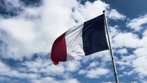 a flag of france flying in the must with the blue sky