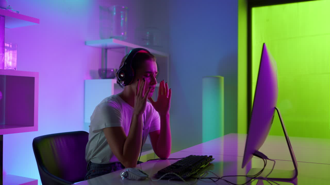 Donna delusa che perde un torneo di eSport nella sua accogliente stanza di casa. Ragazza al neon delusa.