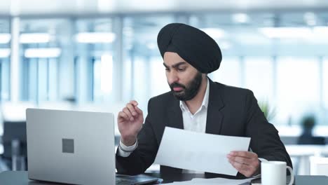 stressed and tensed sikh indian businessman working on laptop