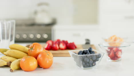 delicious colourful fruits lying on white counter in sunny kitchen