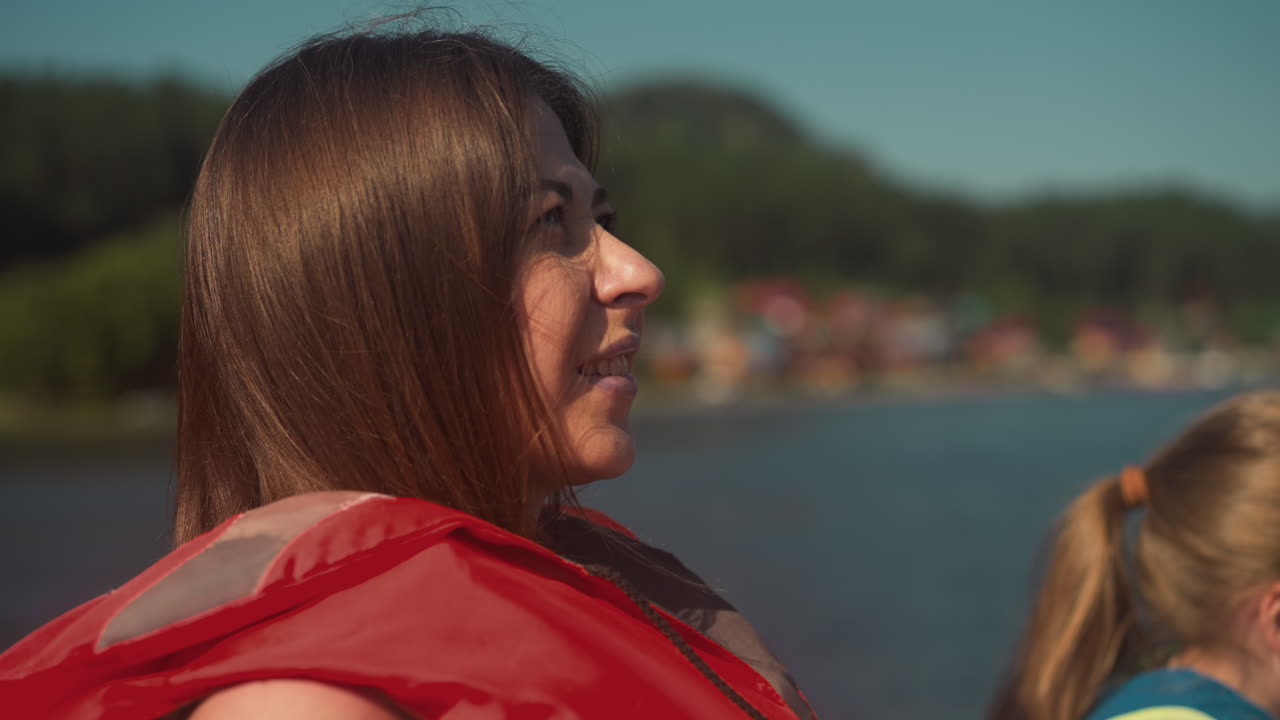 은 구명조끼를 입은 여성 여행자는 딸과 함께 리조트에서 휴가를 즐기고 있습니다.