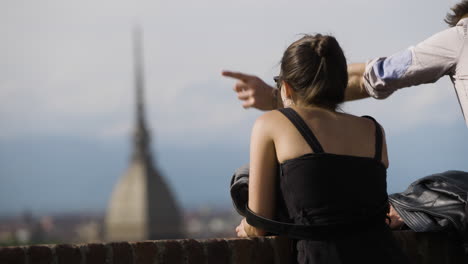 a tourist couple looking over blurry skyline of turin italy