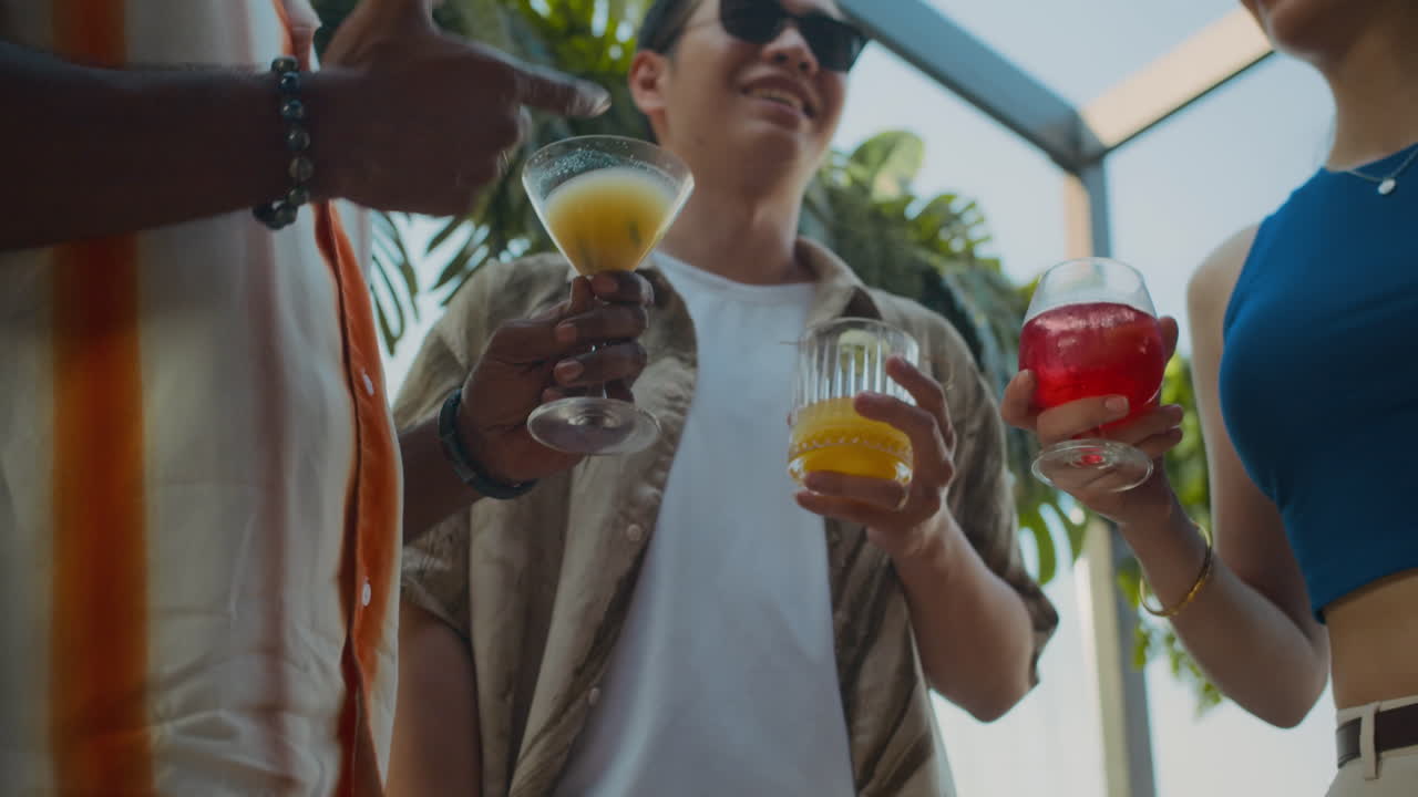 Biracial Friends Toasting with Cocktails in Cafe Low Angle