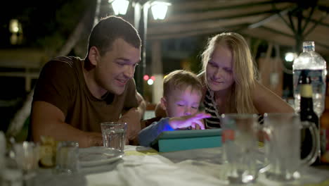 Familie-Mit-Tablet-PC-Im-Straßencafé