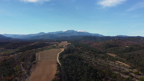 mountainous landscape with farmland and snow-capped peak