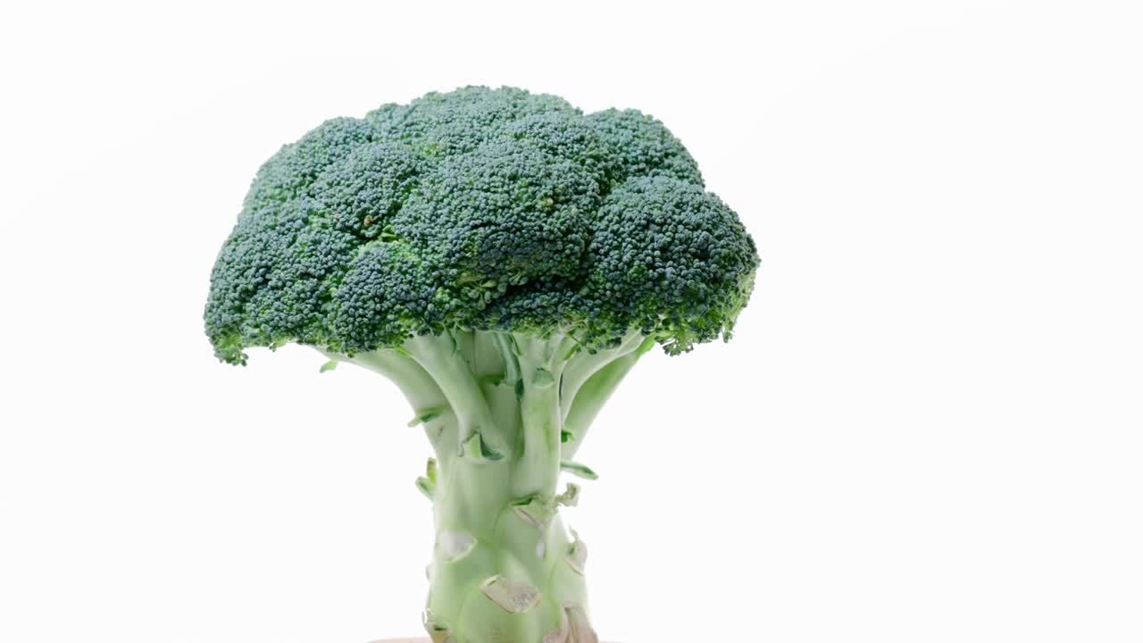 Fresh raw broccoli rotating over white background