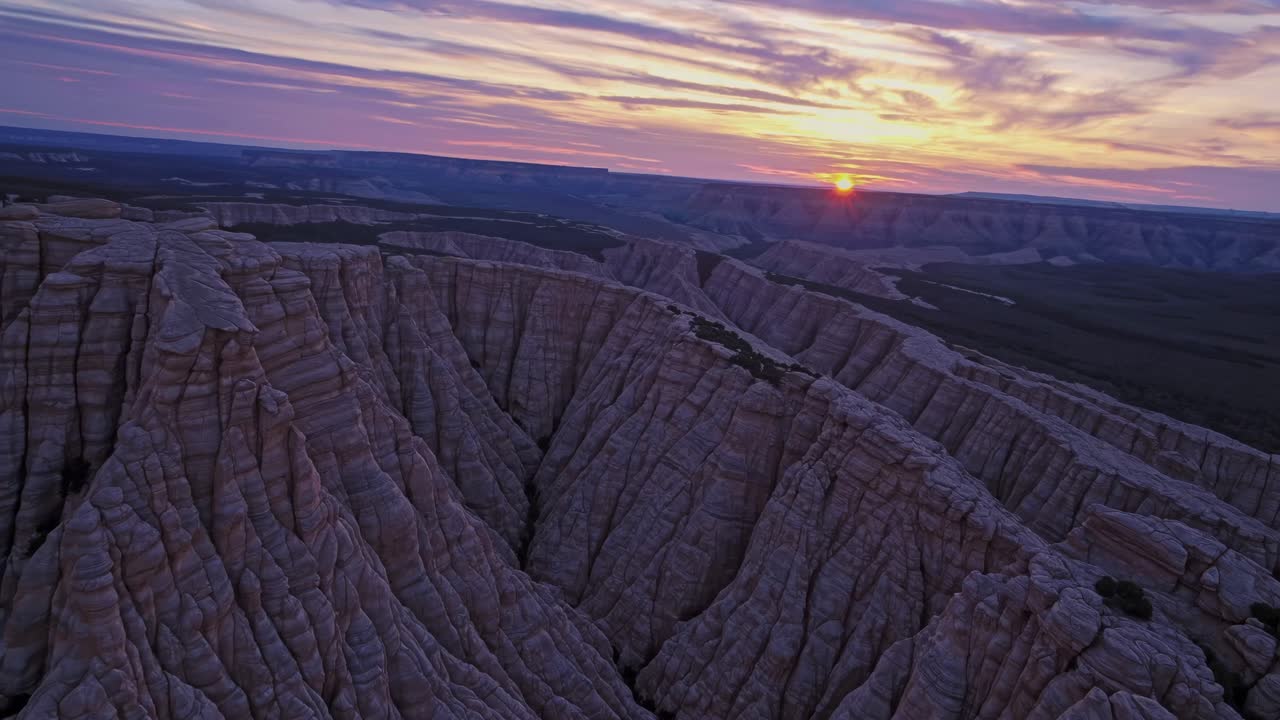 Aerial view of dramatic canyon landscape at sunset, capturing deep shadows and vibrant skies