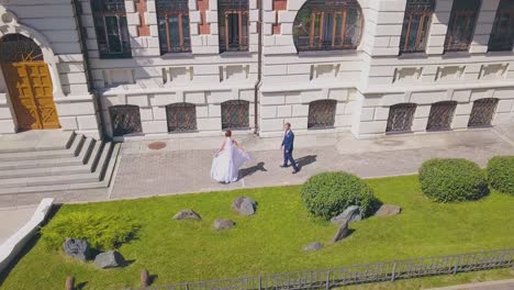 bride in gorgeous dress with groom near building upper view