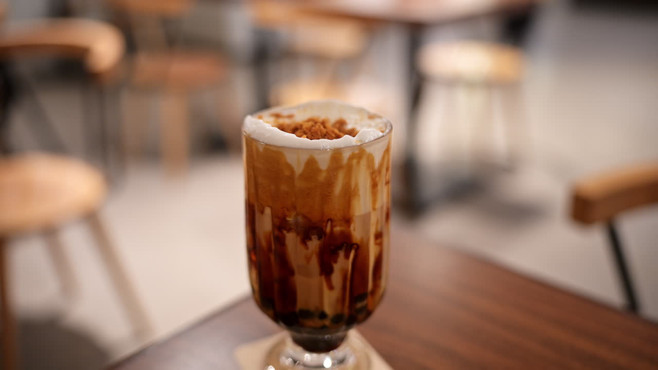 Teh susu mutiara Taiwan dengan mutiara tapioka hitam di kafe Hong Kong. Representasi visual tren minuman Asia populer dan budaya makanan konsumen global