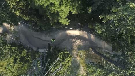 top shot of a mountain biker riding in the forest on a mountain trail