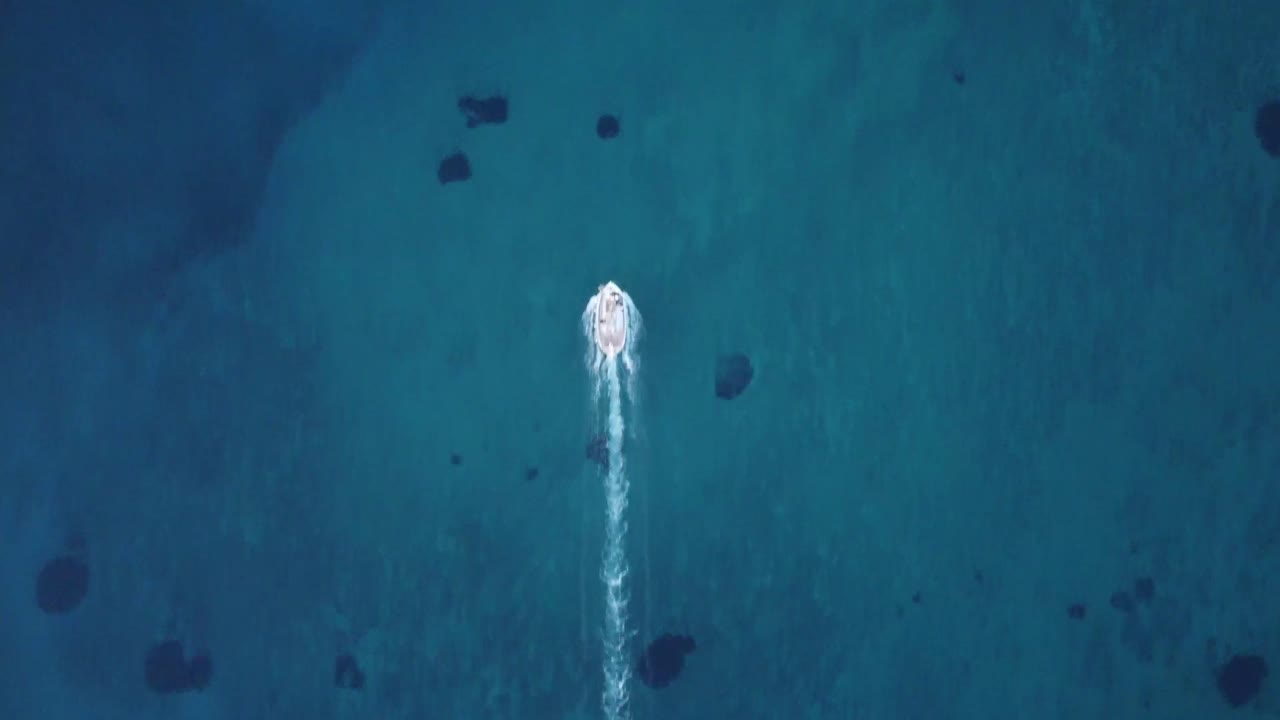 barco de pescadores cinematográfico que deja un largo rastro de agua detrás de sí mismo