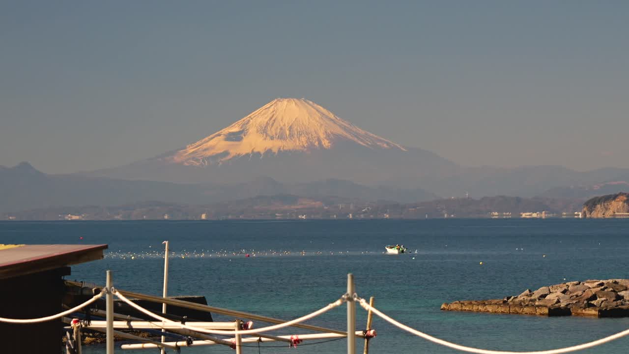 Betagende udsigt over Fuji-bjerget og Enoshima med en lille fiskerbåd.