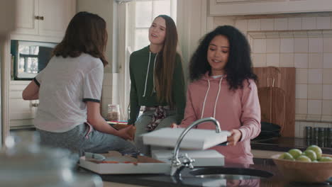 Un-Grupo-De-Chicas-Adolescentes-Comiendo-Pizza-En-La-Cocina-Divirtiéndose-Charlando-Juntas-Compartiendo-El-Estilo-De-Vida-Con-Amigos-Disfrutando-Relajándose-En-Casa