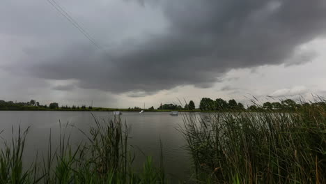 Lapso-De-Tiempo-De-La-Nube-De-Tormenta-Deslizándose-En-El-Cielo-Sobre-Un-Lago-Tranquilo,-Ondas-Azotadas-Por-El-Viento