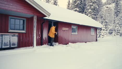 Man-Going-Outside-From-Cabin-In-Winter-Landscape-In-Indre-Fosen,-Norway---wide