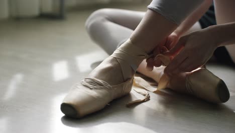 ballet dancer tying pointe shoes