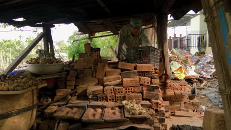 vista interior de personas que trabajan arduamente en una pequeña tienda de cerámica en thanh ha, capturando el arte y la artesanía de la alfarería