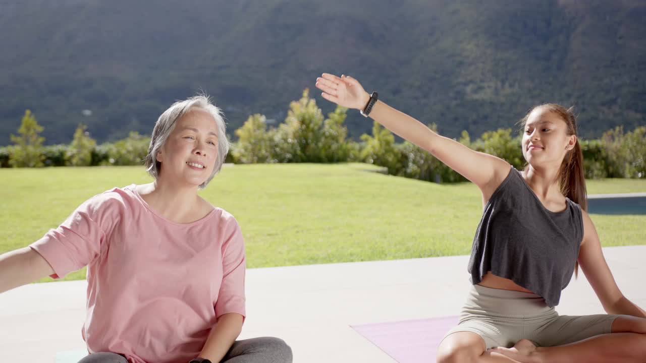 Practicing yoga outdoors, two women stretching and enjoying nature together, copy space