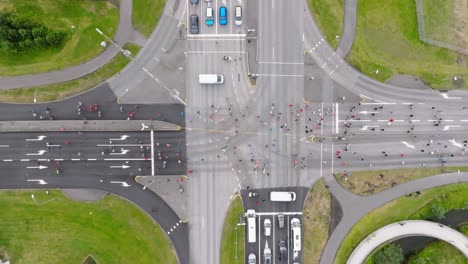 Closed-road-intersection-with-marathon-attendees-running-across,-top-down