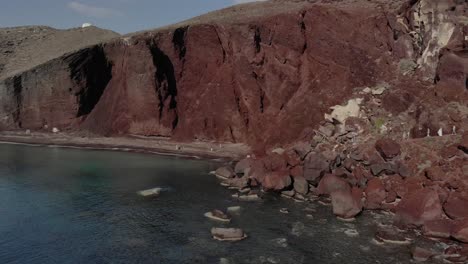 aproximación aérea a los acantilados de la playa roja de kokkini paralia en santorini griego