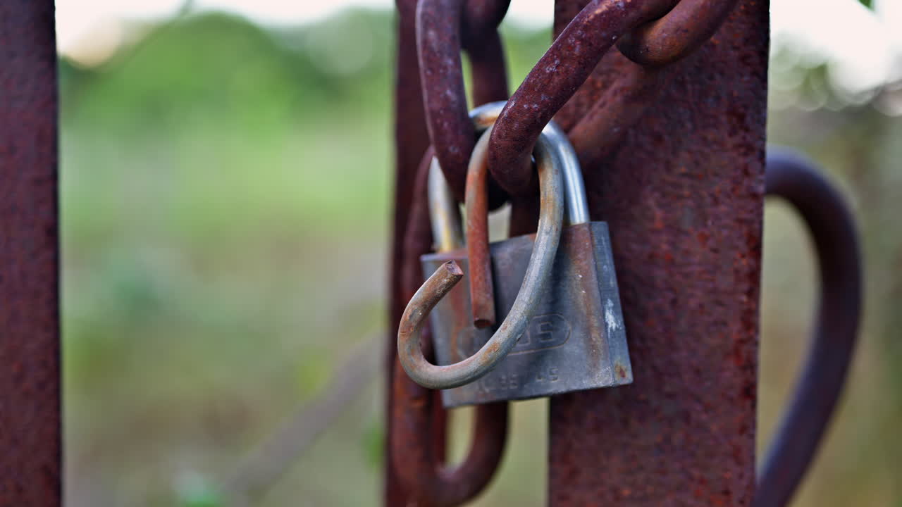 Close up of a lock closing a rusty gate