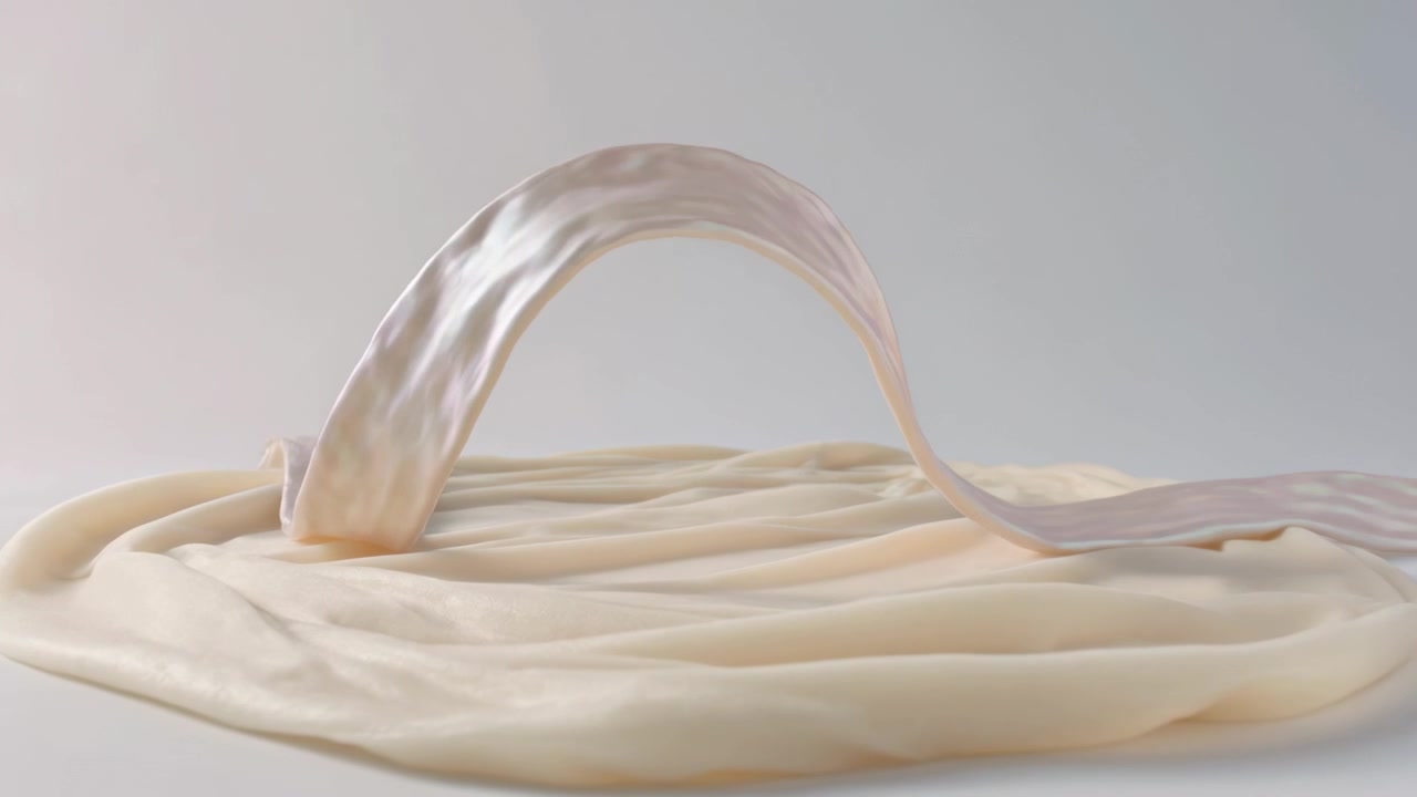 Lifting pale glossy cream rising from pooled base, forming smooth arched ribbon on studio tabletop