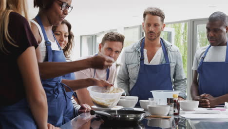 Profesora-Haciendo-Pan-Plano-En-La-Cocina-En-Clase-De-Cocina-Mientras-Los-Estudiantes-Adultos-Miran