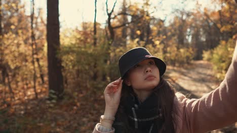 woman taking a selfie in a park during fall