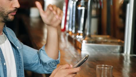 Smiling-man-using-mobile-phone