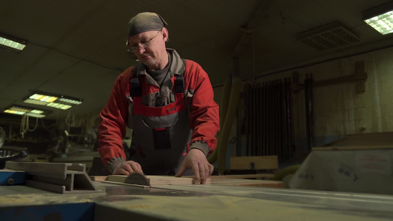carpintero, trabajador corta una tabla de madera con una sierra circular en un banco de trabajo