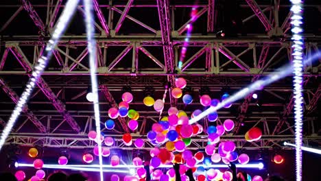 balloons flying in the night air at a concert