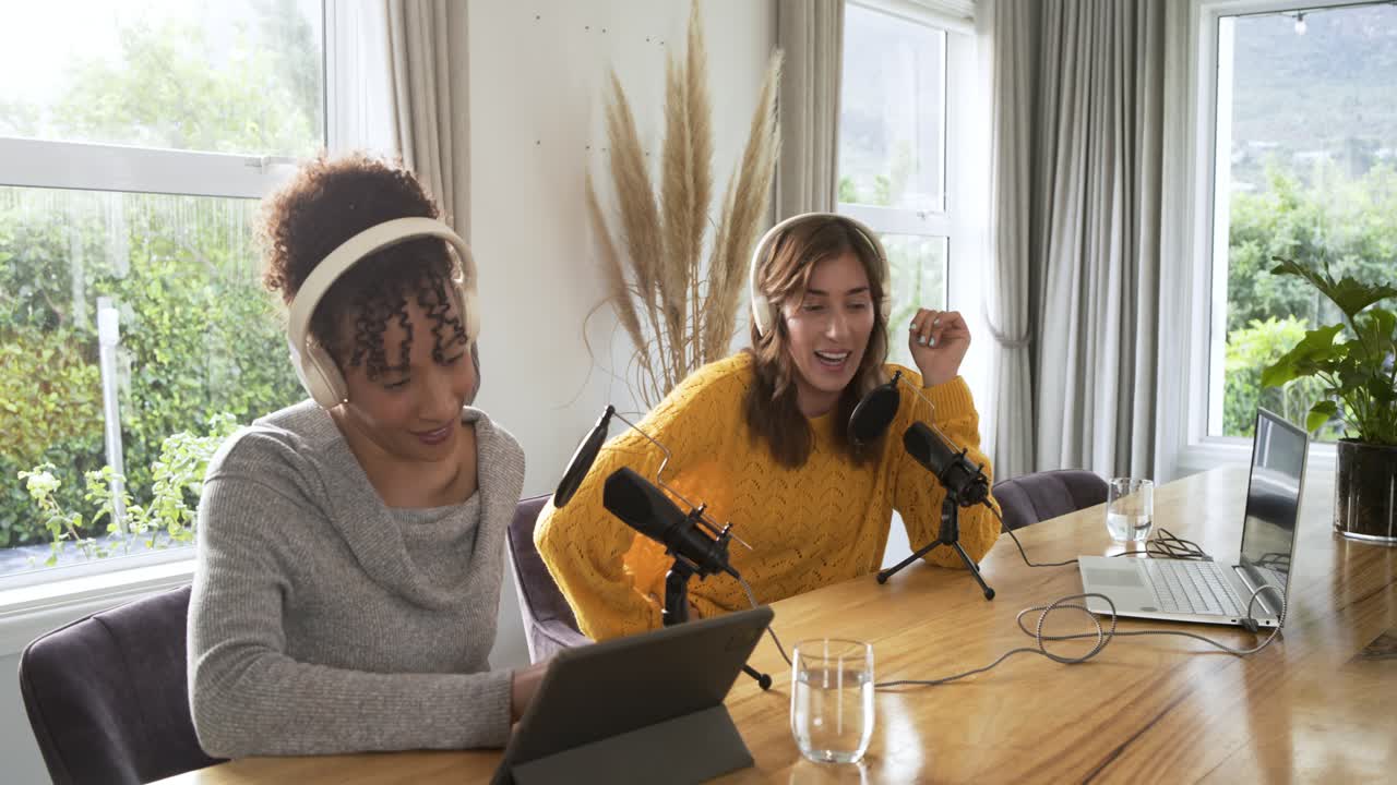 Diversas co-apresentadoras batendo no microfone e cantando após deslizar o tablet para tocar áudio na mesa.