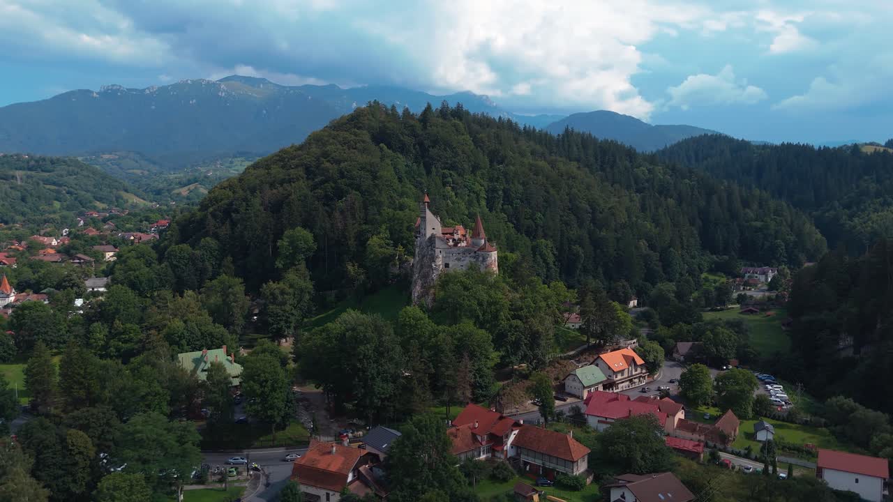 Orman ve köy evleriyle çevrili Bran Kalesi üzerinde drone ile yapılan panoramik çekim.