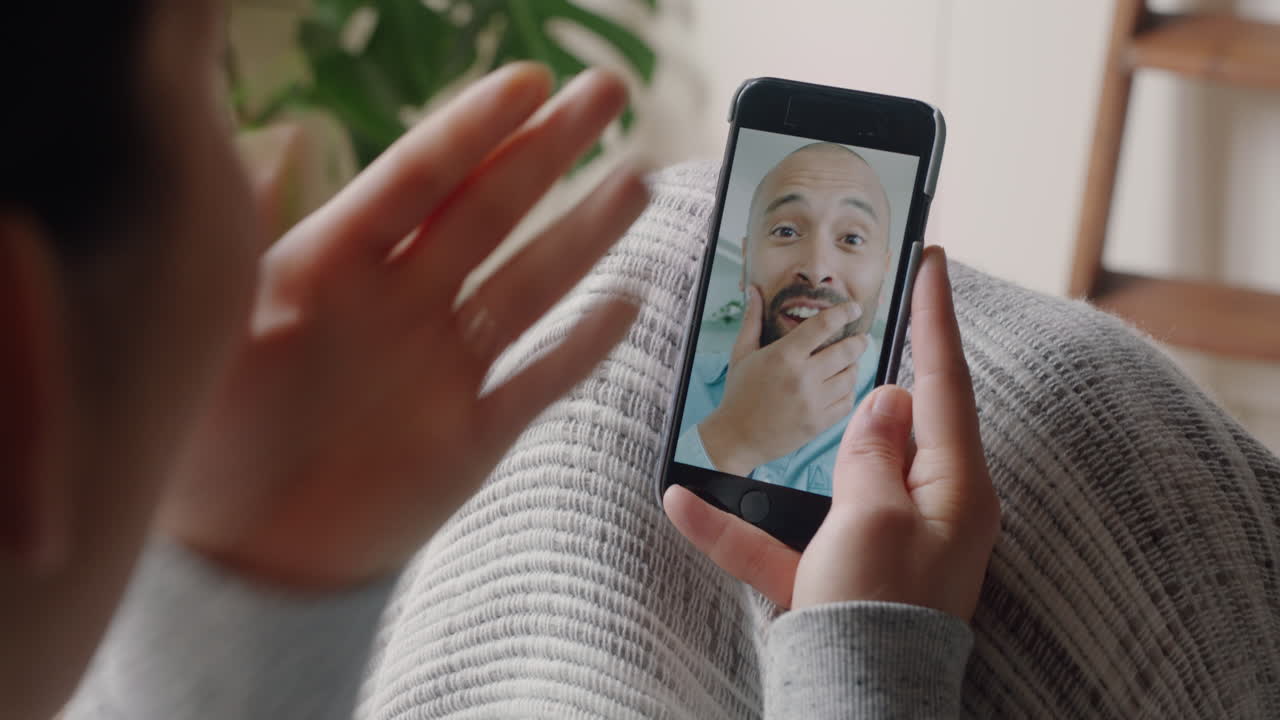 mujer joven teniendo video chat usando smartphone en casa hablando con su novio disfrutando de la conversación compartiendo estilo de vida comunicándose con el teléfono móvil