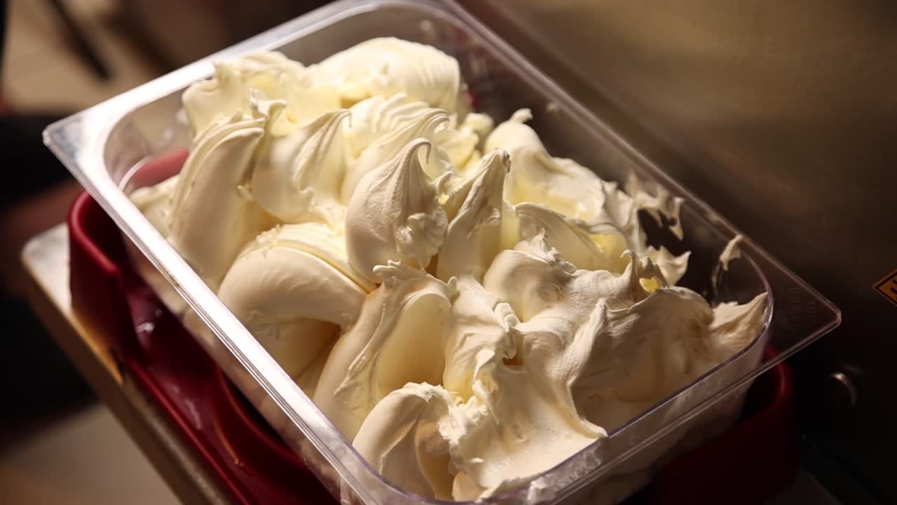 Primo piano di gelato bianco cremoso in un contenitore di plastica