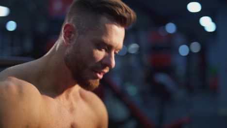 handsome sportsman resting after hard training. portrait of a young shirtless athlete breathing hard after doing workout in the gym. close-up.
