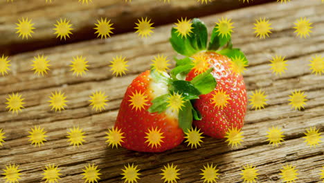 strawberries on wooden surface, yellow star animation overlay in background