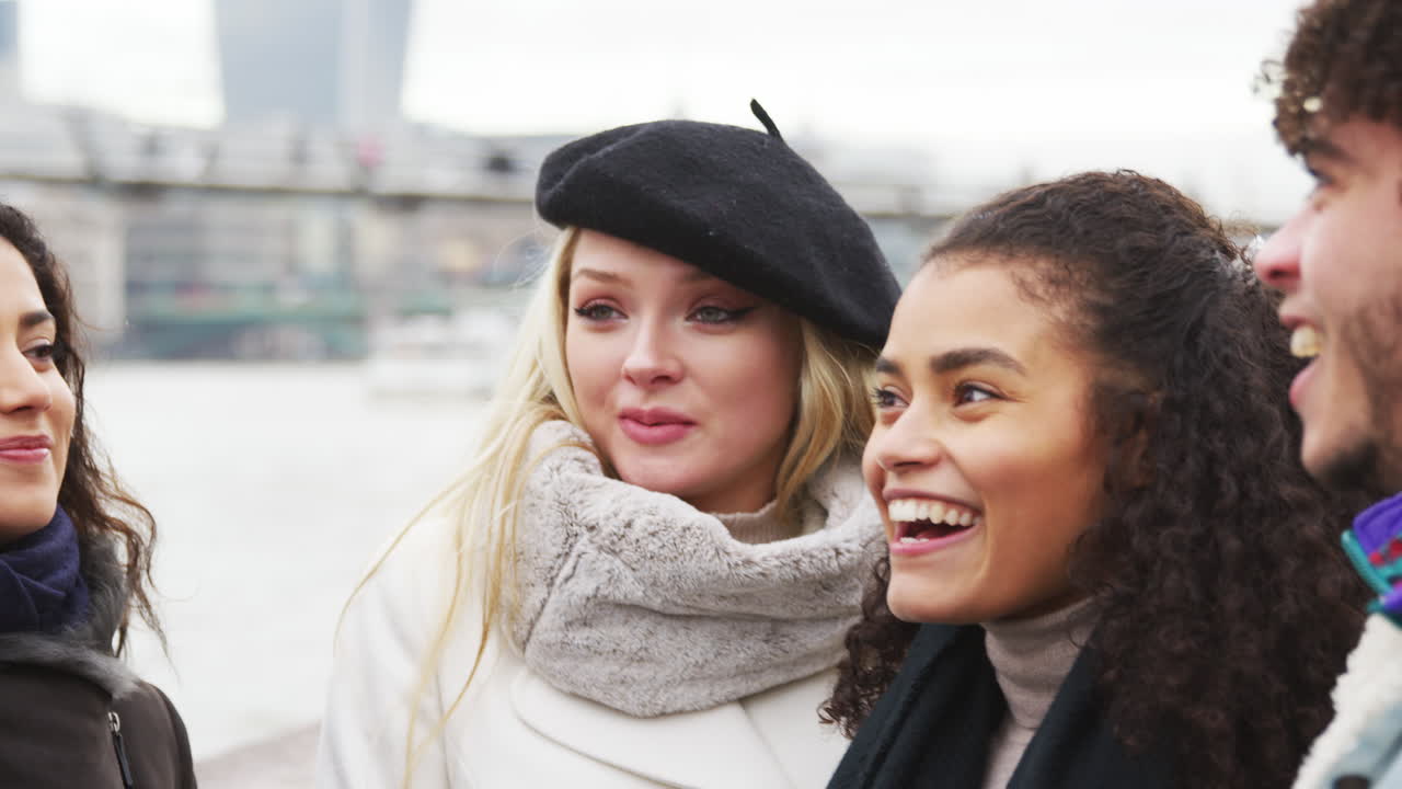 Amici che camminano lungo la South Bank durante una visita invernale a Londra.