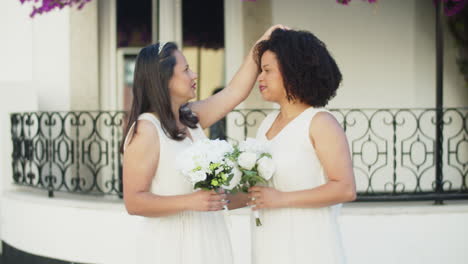 handheld shot of lesbian couple kissing before wedding ceremony