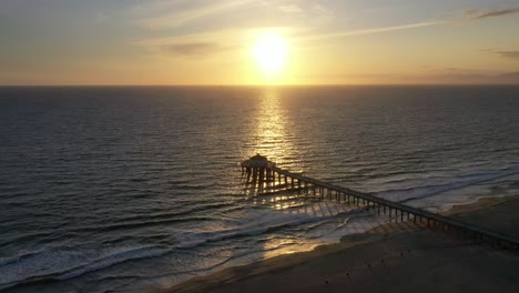 Puesta-De-Sol-Reflejada-En-El-Océano-Hacia-El-Muelle-De-La-Playa-De-Manhattan-En-California,-Ee.uu.