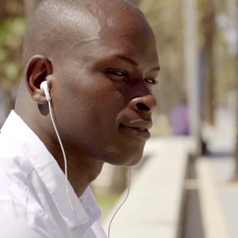 close up side view of man with ear buds in white