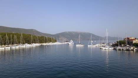 drone forward in picturesque port of fiskardo, greece, sunny summer day