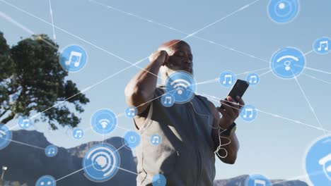 Animation-of-network-of-connections-over-senior-african-american-man-using-smartphone-at-beach