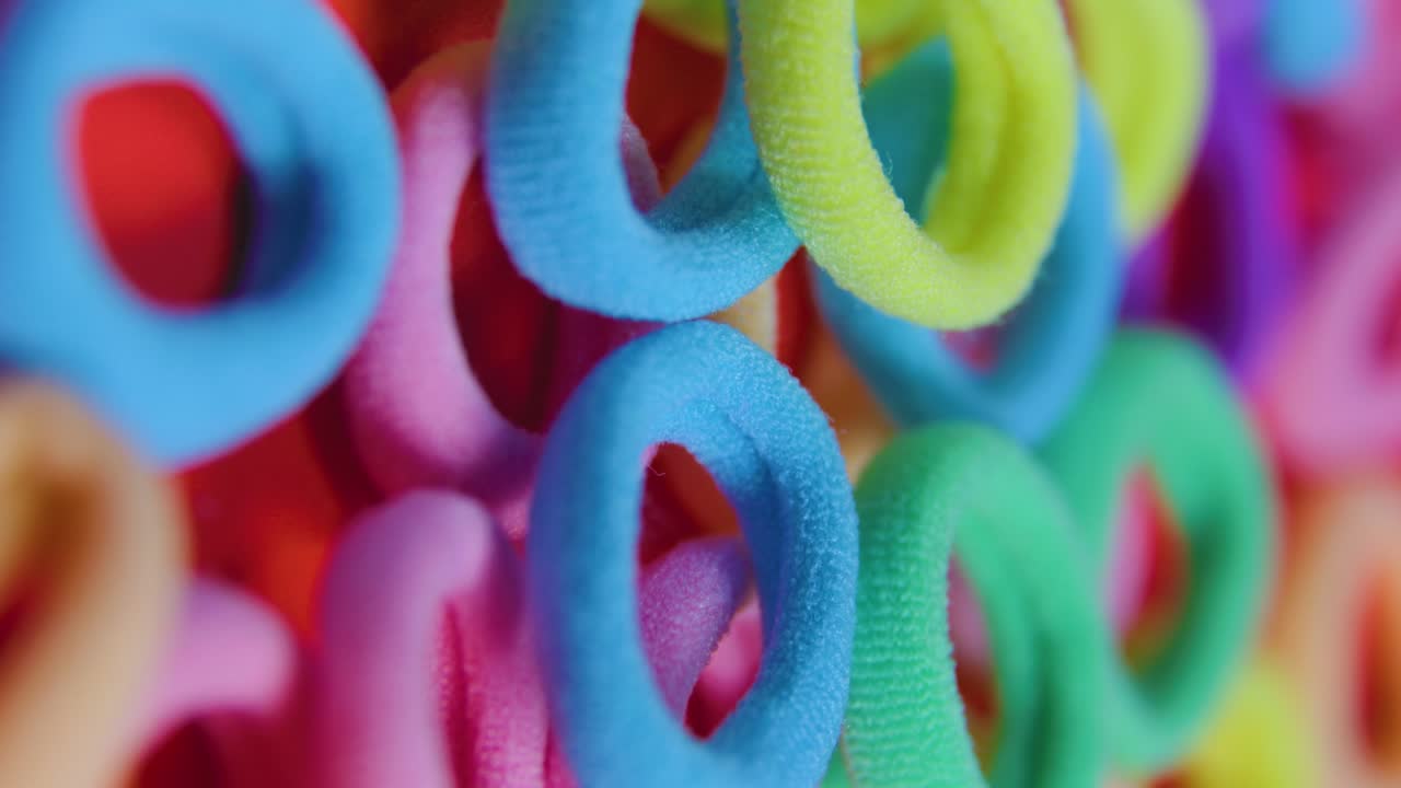 bandas de goma de varios colores fondo rojo pantalla vertical 4k