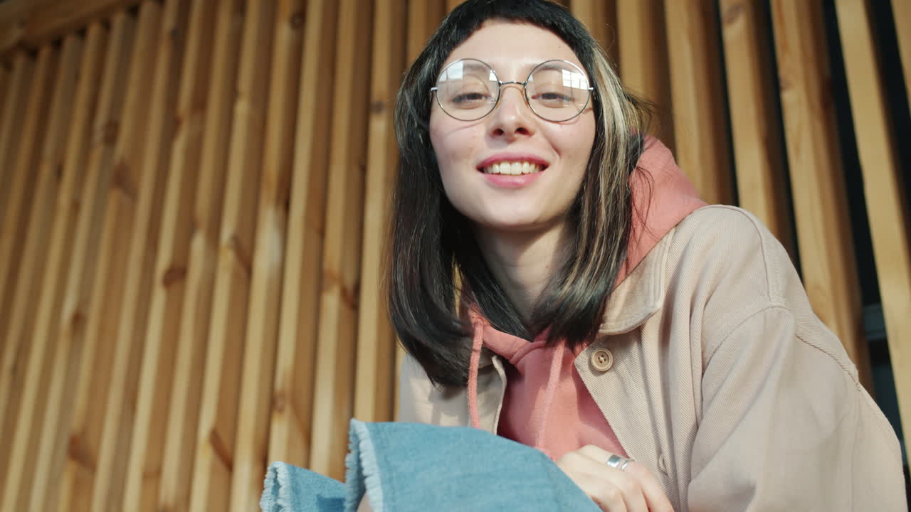 Young Woman in a Hoodie and Glasses
