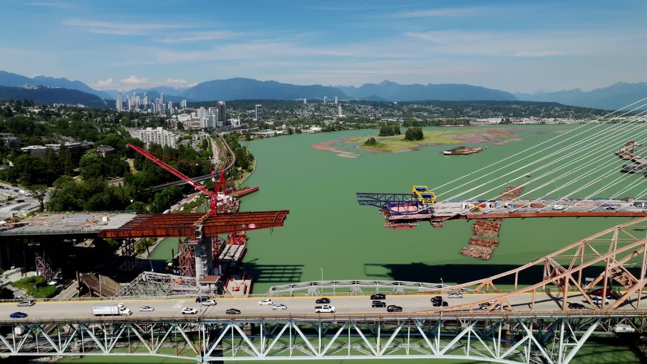 The Pattullo Bridge Replacement is Under Construction Over the Fraser River in Vancouver, British Columbia, Canada - Aerial Pullback Shot