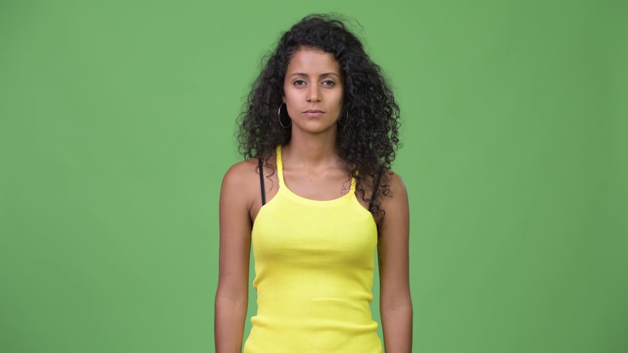 Young beautiful Hispanic woman pointing up
